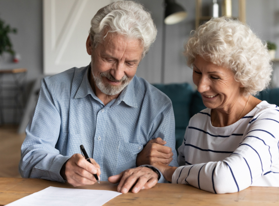 Older white couple signing paperwork