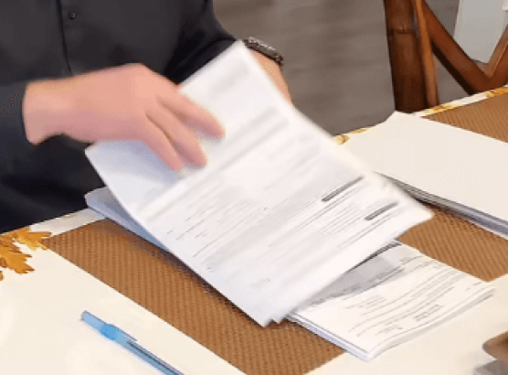 Tony Benson hands going through loan paperwork